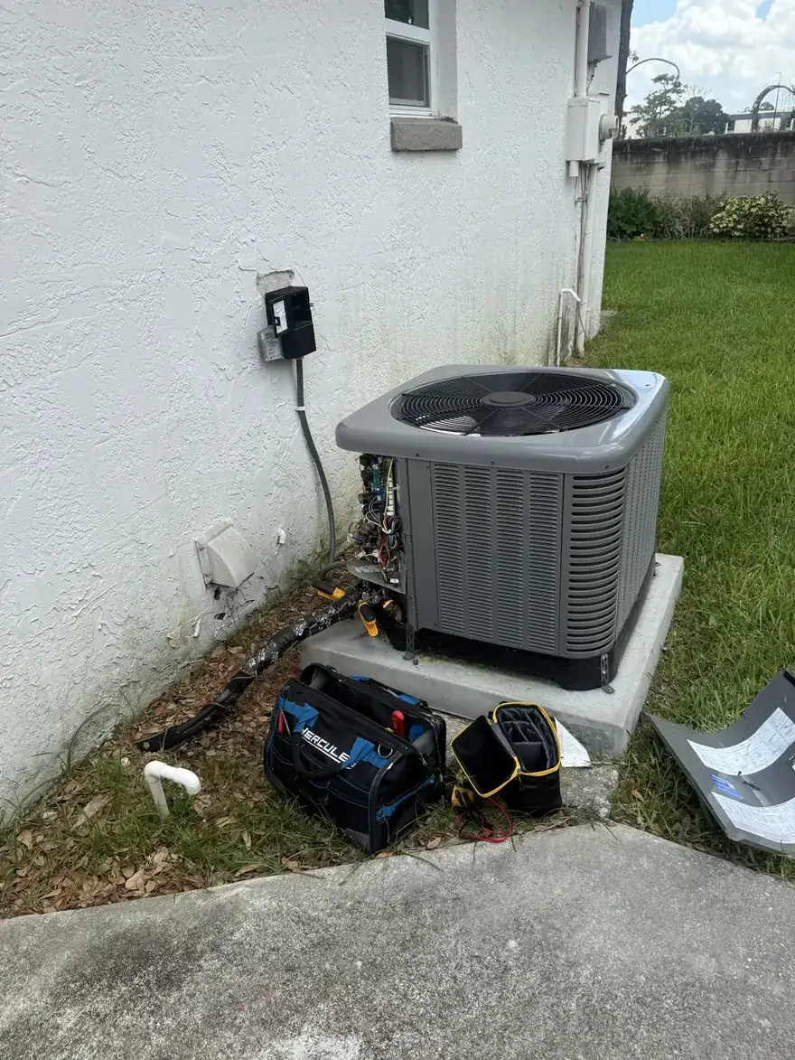 Launchpad technician diagnosing an AC condenser with the service panel open
