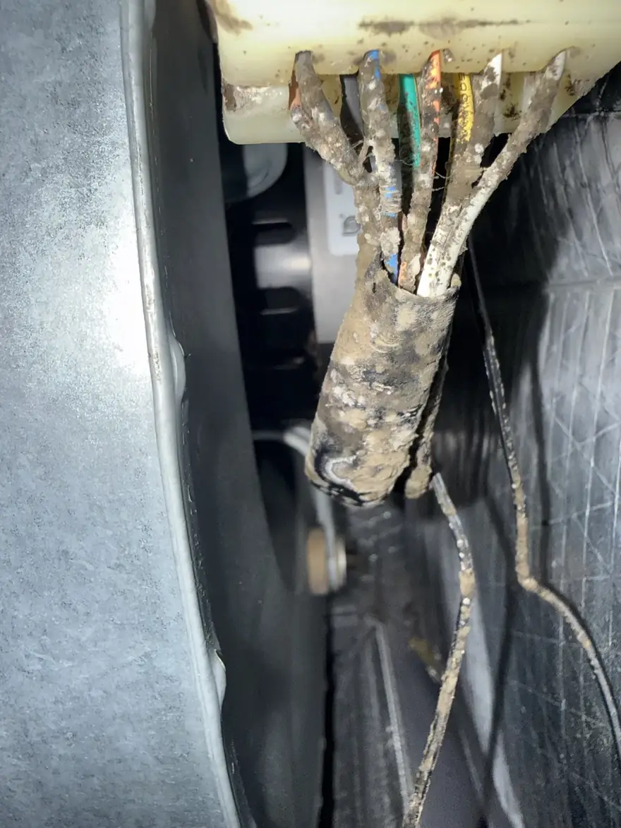 Corroded, debris-covered wiring harness found inside an air handler